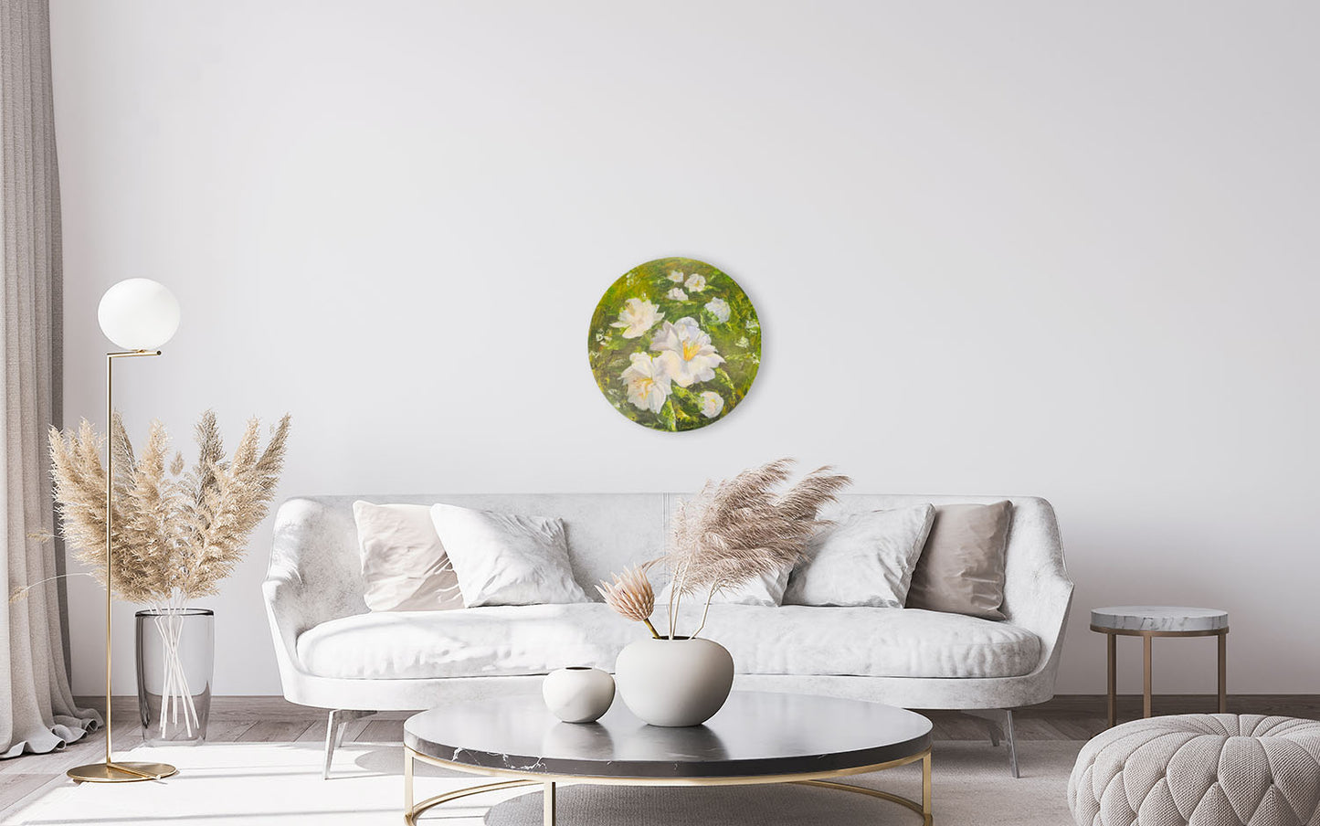 Modern living room with a white sofa, round coffee table, and decorative wall art.