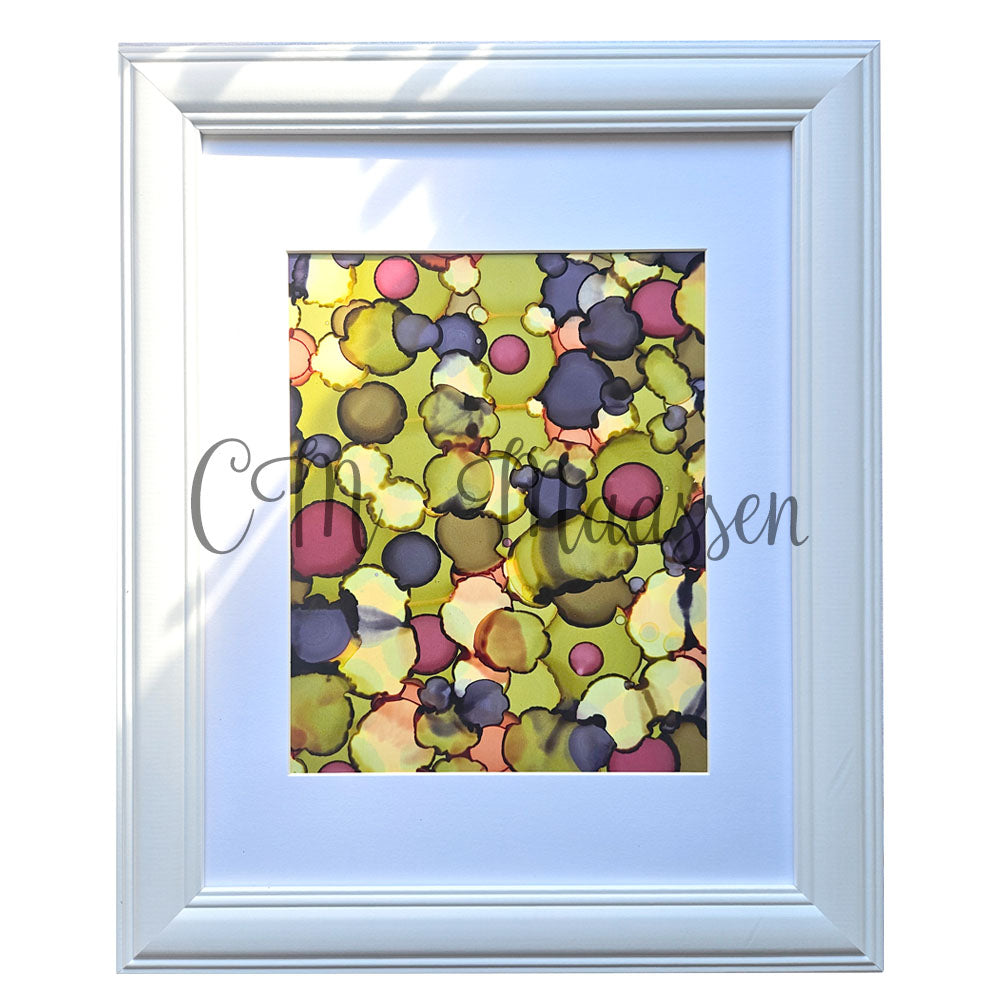 Framed abstract artwork with colorful circles and a white border.