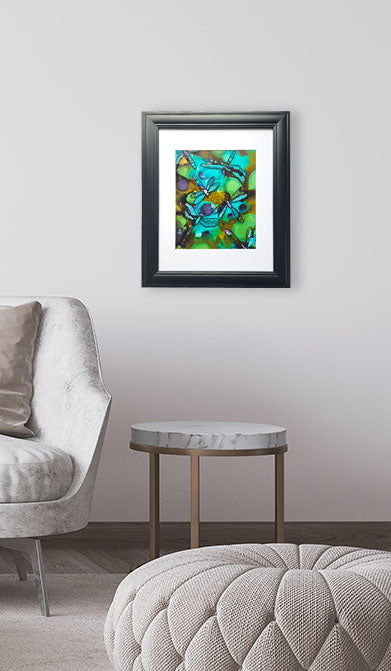 Framed abstract painting on a wall above a round table in a living room setting.