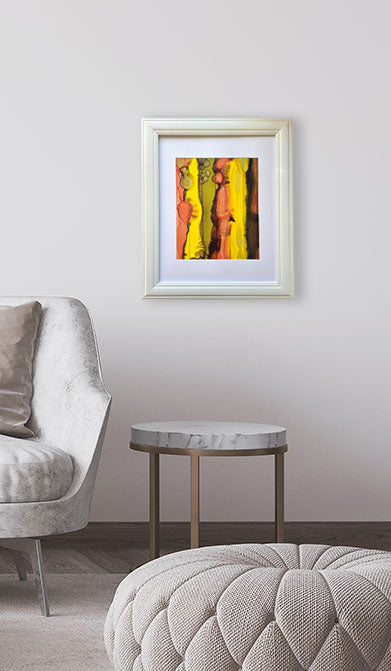 Framed abstract art on a wall above a round marble table in a living room.