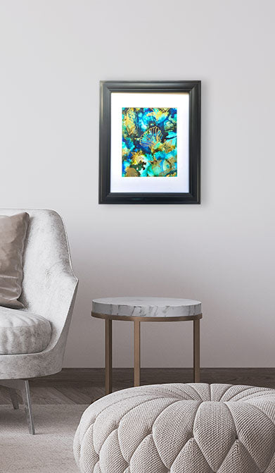 Framed abstract painting on a wall above a round table in a living room setting.