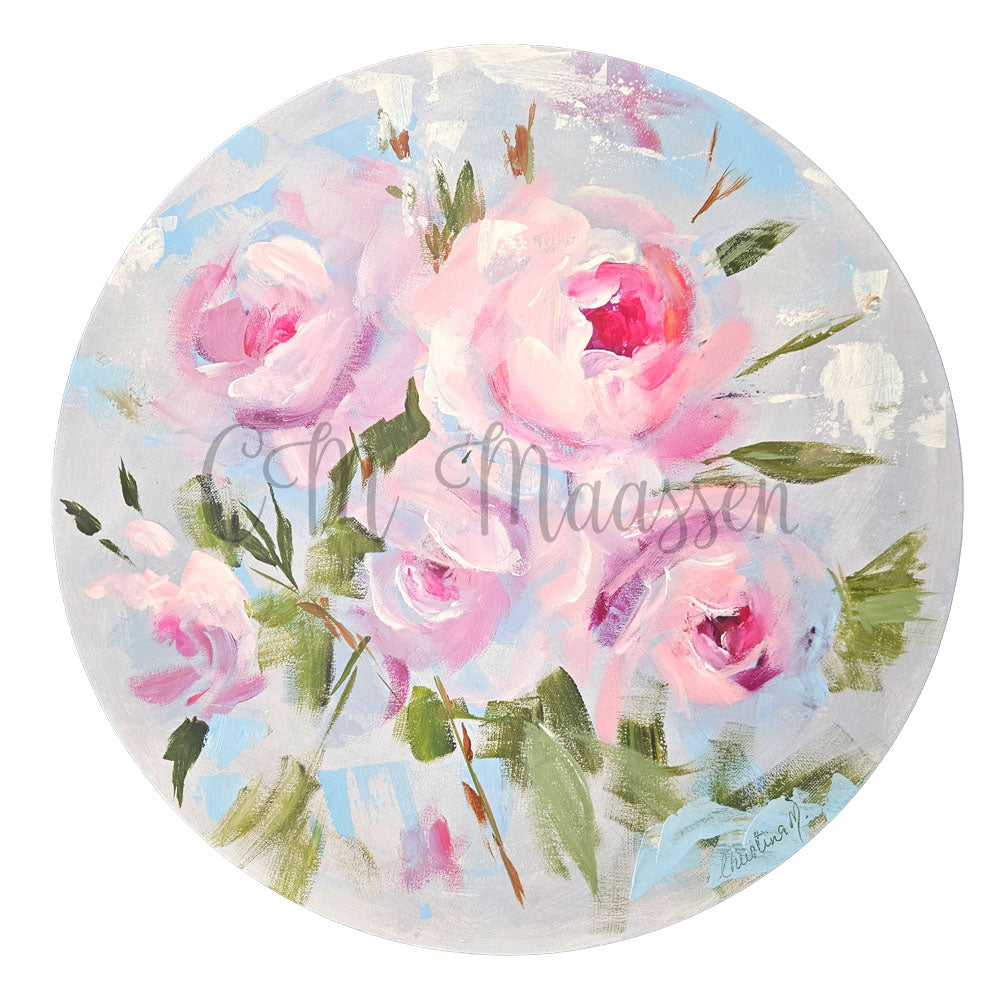 Round decorative item with pink roses and green leaves on a light background